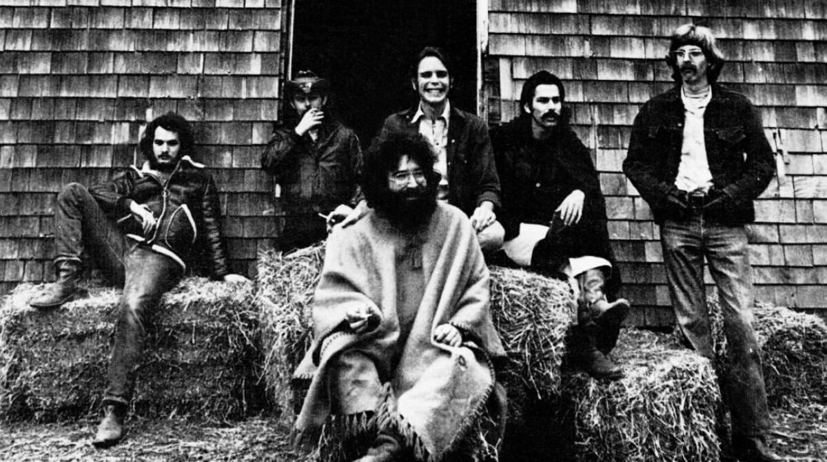 Black and white 1970 photo of the Grateful Dead posed outside a barn, used in a Billboard trade advertisement for American Beauty