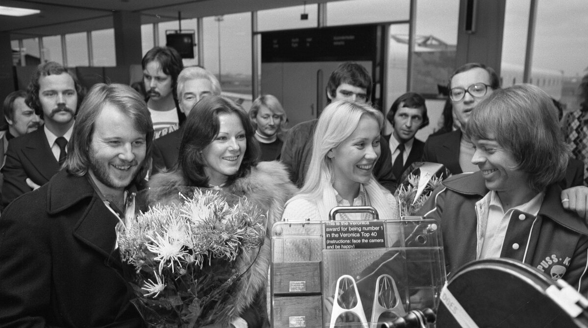 ABBA arriving at Amsterdam's Schiphol Airport in November 1976, the same year Knowing Me, Knowing You was recorded for the album Arrival