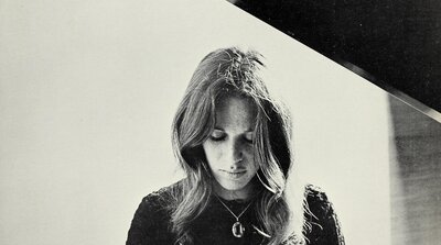 Carole King seated at a piano in a 1971 publicity photo