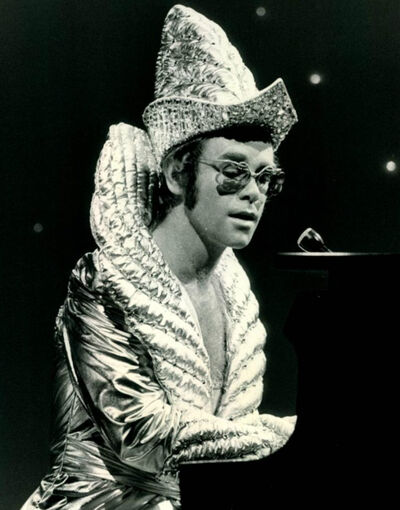 Elton John in a 1975 costume, a related Artists post covering his 70s hits