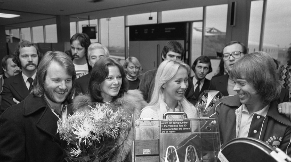 ABBA greeted with flowers and a number one award at Schiphol Airport in the Netherlands in 1976, the year before the band wrote The Name of the Game